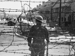 Ein bewaffneter Wachmann in einem Internierungslager