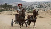 Josh Gates fährt als römischer Zenturio verkleidet auf einem Streitwagen in Amman, Jordanien. Josh Gates fährt als römischer Zenturio verkleidet auf einem Streitwagen in Amman, Jordanien.