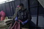 Deckhand Willi Manchester prepares the hose for use aboard the Brenna A.