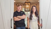 Hosts Chip and Joanna Gaines stand at the sliding doors to Ermoian's newly remodeled office, as seen on Fixer Upper.