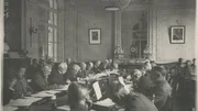Mitglieder eines Komitees 1919, die sich Dokumente f&uuml;r den Friedensvertrag in Versailles durchlesen.