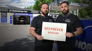 Engin (l.) und Serkan Kaya (r.) halten vor ihrer Werkstatt ein Schild mit der Aufschrift "KFZ-Prüfer gesucht" in den Händen. Engin (l.) und Serkan Kaya (r.) halten vor ihrer Werkstatt ein Schild mit der Aufschrift "KFZ-Prüfer gesucht" in den Händen.