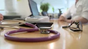 Patientengespr&auml;ch mit Stetoskop auf Tisch.