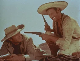 Obwohl sie sich gegenseitig nicht &uuml;ber den Weg trauen und einander st&auml;ndig hintergehen, haben Joe (Clint Eastwood, l.) und Tuco (Eli Wallach, r.) sich auf eine eintr&auml;gliche Zusammenarbeit geeinigt: Joe liefert seinen steckbrieflich gesuchten Partner gegen das Kopfgeld dem Sheriff aus und rettet ihn dann in letzter Sekunde vor dem Galgen ...