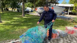 Der Grenzschutzbeamte Zlatko Krusharoski untersucht beschlagnahmte Fischernetze