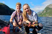 Kaja hat einen Fisch perfekt ausgenommen und beeindruckt damit Mitschüler Lukas.