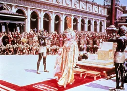 Imperien treffen aufeinander, &Auml;gypten in Rom: Cleopatra (Elizabeth Taylor) ist in Rom angekommen und hat sich von ihrem Thron erhoben, um Caesar und Marcus Antonius zu begr&uuml;&szlig;en.