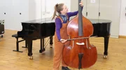 Marina darf bei der Jungen Staatsphilharmonie in Nürnberg das Kontrabassspielen ausprobieren.