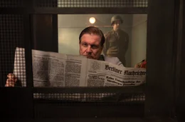 Sonderberichterstatter 104995? Wer soll das sein? Herman G&ouml;ring (Francis Fulton- Smith) st&ouml;&szlig;t in der Zeitung auf den Namen Ernst Michel.