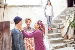 Fatma (Nursel K&ouml;se, r.) t&auml;tschelt Mehmet (Luk Piyes, l.) die Wange, um ihn vom Hof des Hauses zu verscheuchen, weil sie mit Vicky (Christiane Paul, M.) alleine kochen will.