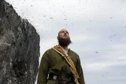 Reenactors Wikinger in einer T&ouml;lpel-Kolonie mit hunderten von T&ouml;lpel, die &uuml;ber Bass Rock in Schottland fliegen.