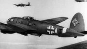 Eine Formation deutscher Bomber aus dem Zweiten Weltkrieg ist im Flug zu sehen, mit deutlich sichtbaren Hakenkreuz- und Balkenkreuz-Symbolen. Die Flugzeuge fliegen über die Landschaft und stehen für die Luftmacht und Symbolik des NS-Regimes.