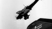 Ein Junkers Ju 87 Stuka-Sturzkampfflugzeug ist im Flug zu sehen und zeigt seine charakteristischen Möwenflügel und das feste Fahrwerk. Das Bild hebt das markante Design dieses Flugzeugs aus dem Zweiten Weltkrieg hervor und steht für den technologischen Ehrgeiz jener Epoche.