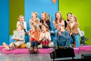 Das Studiopublikum applaudiert und lacht.