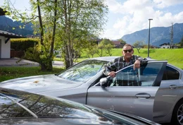 Wolfgang Ambros vor seinem Auto bei seinem Haus in Waidring in Tirol. Er macht sich bereit auf die Alm zu fahren.