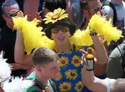 Mit Sonnenblumenschmuck und gelber Boa tanzt ein Raver am 10. Juli 1999 in Berlin. Bei der Loveparade erwarten die Veranstalter mehr als eine Million Teilnehmer aus aller Welt in der Hauptstadt.