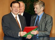 Der designierte Bundeskanzler Gerhard Schröder (l.) und der designierte Außenminister Joschka Fischer (r.) von den Grünen präsentieren nach der Unterzeichnung den rot-grünen Koalitionsvertrag in der NRW-Landesvertretung in Bonn.