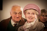 Victor (Roy Hudd,l.) und Stella Spencer (Patricia Brake, r.) freuen sich über satte Einnahmen bei der Weihnachtskollekte, Komparsin (h.r.).