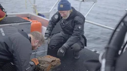 Nach dem Tauchgang untersucht der Unterwasserarch&auml;ologe Dr. Florian Huber (l.) die gefundene Enigma.