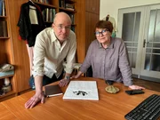Die Textil-Expertin Dr. Maria Cybulska von der Technischen Universität Łódź (rechts) zeigt dem Gesichtsrekonstrukteur Oscar Nilsson (links) Stoffreste, die im Grab des geheimnisvollen Vampir-Skeletts gefunden wurden.