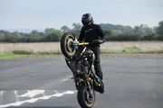 Dunsfold, Guildford, UK: A motorbiker pulling a wheelie. Dunsfold, Guildford, UK: A motorbiker pulling a wheelie.