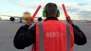 "Auf diesen Moment kommt es an, jetzt darf nichts schief gehen!" Das neue Dokutainment-Format des rbb, 100% Berlin, bringt uns ganz nah heran an die kleinen und großen Dramen Berlins. Ob auf einer Neugeborenenstation, unterwegs mit dem Zoll oder hinter den Kulissen des BER: Wir erleben hautnah mit, wie viele Menschen Tag und Nacht Großes leisten, um die Stadt am Laufen zu halten. - Timo Krieg winkt eine Boeing 787 ein.