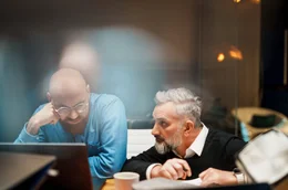 Hacker Marco di Filipo (r.), KI-Experte Benjamin Bertram (l.) und vier weitere Expert:innen nutzen verschiedene KI-Systeme, um innerhalb von sechs Wochen einen virtuellen Politiker zu erschaffen.