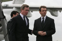 Tony Blair (Michael Sheen, r.) begr&uuml;&szlig;t Prinz Charles (Alex Jennings, l.) nach dessen R&uuml;ckkehr aus Paris am Flughafen. Charles hat die Leiche Dianas nach London &uuml;berf&uuml;hrt.