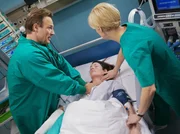 Martin Stein (Bernhard Bettermann, links) glaubt, dass nur noch die Amputation ihrer Hand Elenas (Cheryl Shepard, Mitte) Leben retten kann. Kathrin Globisch (Andrea Kathrin Loewig) und die anderen Ärzte teilen den Vorschlag nicht; Elenas Zustand verschlechtert sich.