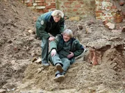 In einer Baugrube in der Leipziger Innenstadt wird eine Bombe gefunden. Nach der ersten Einschätzung der Lage stürzt Bombenentschärfer Peter Merz (Hartmut Schreier, rechts) und verletzt sich am Bein. Sein jüngerer Kollege Daniel Schlösser (Christian Blümel) hilft ihm und ruft den Notarztwagen.
