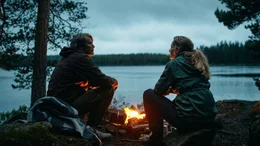 Martin (Mads Mikkelsen, li.) sitzt mit Anika (Maria Bonnevie) am Lagerfeuer.