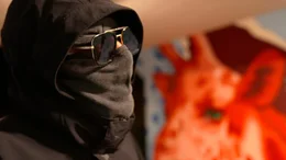 Ein Bandenmitglied spricht vermummt &uuml;ber die kriminellen Strukturen