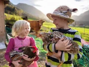 Georgina und Martin vor dem H&uuml;hnerstall auf dem Dickengschwendtnerhof in Ruhpolding.
