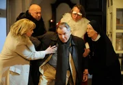 Schwester Felicitas (Karin Gregorek, rechts) muss zusammen mit Marianne Laban (Andrea Wildner), Hermann Huber (Wolfgang Müller, 2.v. links) und Kulturdezernent Wimberger (Frank Treptow) den fassungslosen Bürgermeister Wöller (Fritz Wepper) stützen, der nach einer unerfreulichen Nachricht in Ohnmacht fällt.