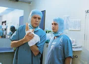 Dr. Stefan Frank (Sigmar Solbach, li.) und Assistenzarzt Dr. Peter Stein (Zacharias Preen) haben gerade die Schusswunde von Fredi operiert.