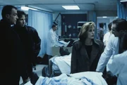Mulder (David Duchovny, 2.v.l.) und Scully (Gillian Anderson, 2.v.r.) vermuten, dass die Bewohner, die ins Krankenhaus eingeliefert wurden, mit au&szlig;erirdischen Lebensformen in Ber&uuml;hrung kamen. Doch k&ouml;nnen sie davon auch Colonel Calvin Henderson (Marshall Bell, l.) und Dr. Oppenheim (William McDonald, r.) &uuml;berzeugen?