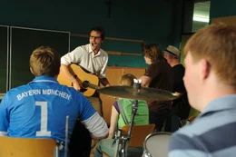 Der letzte Hit seiner Band liegt 15 Jahre zur&uuml;ck, und noch immer hofft Tom (Max von Thun, 2.v.l.) auf ein Comeback. Doch dann pf&auml;ndet ein Gerichtsvollzieher seine geliebte Gitarre. Mit gef&auml;lschten Zeugnissen bewirbt er sich als Musiklehrer an einer F&ouml;rderschule ...