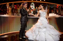 Moderator Caesar Flickerman (Stanley Tucci, l.) ahnt nicht, dass sich unter Katniss' (Jennifer Lawrence, r.) Brautkleid, das sie auf Snows Befehl hin tr&auml;gt, ein schwarzes Spottt&ouml;lpel-Kost&uuml;m versteckt ...