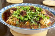 In Chongzhou gibt es den Klassiker Mapo Tofu: Tofu, Fleisch und Gewürze werden angebraten und mit Chili und Frühlingszwiebeln verfeinert.