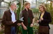 Herr Böttcher (Thomas Chemnitz, l.), Prüfer der Berufsgenossenschaft, untersucht die Arbeitsbedingungen auf dem Gelände des Botanischen Gartens, da Romy Heilands (Christina Athenstädt, r.) Mandant, Tobias Brinitzer (Lucas Prisor, M.), vorgeworfen wird, seine Aufsichtspflicht verletzt zu haben.