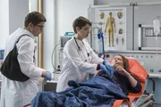 Antonia Lindemann (Marie Gruber, liegend) wird mit Bauchschmerzen in die Notaufnahme eingeliefert. Elias Bähr (Stefan Ruppe, l.) und Dr. Koshka (Katharina Nesytowa, M.) haben gerade Dienst.
