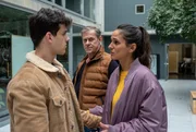 Aziz (Ilyes Raoul Moutaoukkil, l.) und seine Schwester Samira (Aybi Era, r.) unterhalten sich vor Finn (Sven Martinek, h.r.), der das Gespräch aufmerksam beobachtet. Sie wirken dabei sehr emotional.