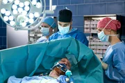 Andre Dietrich (Volker Muthmann, v.M.) wird mit einem schweren Sch&auml;dlebruch eingeliefert. Er wird sofort von Dr. Moreau (Mike Adler, h.M. mit Komparsin, l.) und Julia (Mirka Pigulla, r.) notoperiert.