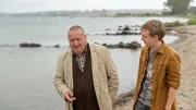 Reuter (Udo Kroschwald, l.) hat einen guten Draht zu Jakob Tiedemann (Jakob Schmidt, r.). Der Junge gesteht dem Kommissar, dass seine Mutter schon eine ganze Weile eine Affäre mit dem Opfer gehabt hat. Immer, wenn die Familie in Wismar mit ihrem Federbetten-Reinigungsdienst gewesen ist, haben die beiden sich getroffen. Ob auch Jakobs Vater von der Affäre gewusst hat? Dann hätte der nämlich ein klares Mordmotiv.