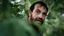 Hans (Jeroen Spitzenberger) muss sich vor dem mysteri&ouml;sen Fahrer im Dickicht verstecken.