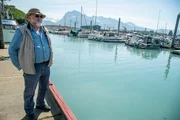 Vern Adkison standing on a dock in a harbor.
