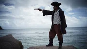 In a recreation, La Buse points his gun in the pirate paradise of the Indian Ocean.