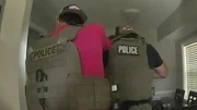 Die Polizei bricht in das Haus ein.