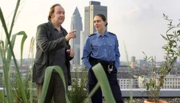 Opa Charly (Ulrich Pleitgen) erl&auml;utert einer Polizisten (Franziska Junge), was er mit seinem Guerilla Gardening bezwecken will.