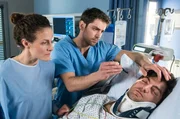 Dr. Niklas Ahrend (Roy Peter Link, Mitte) untersucht Tobias Rasch (Timur Isik, rechts). Auch seine Kollegin und Unfallgegnerin Helena L&uuml;beck (Barbara Lanz) sieht nach ihm.